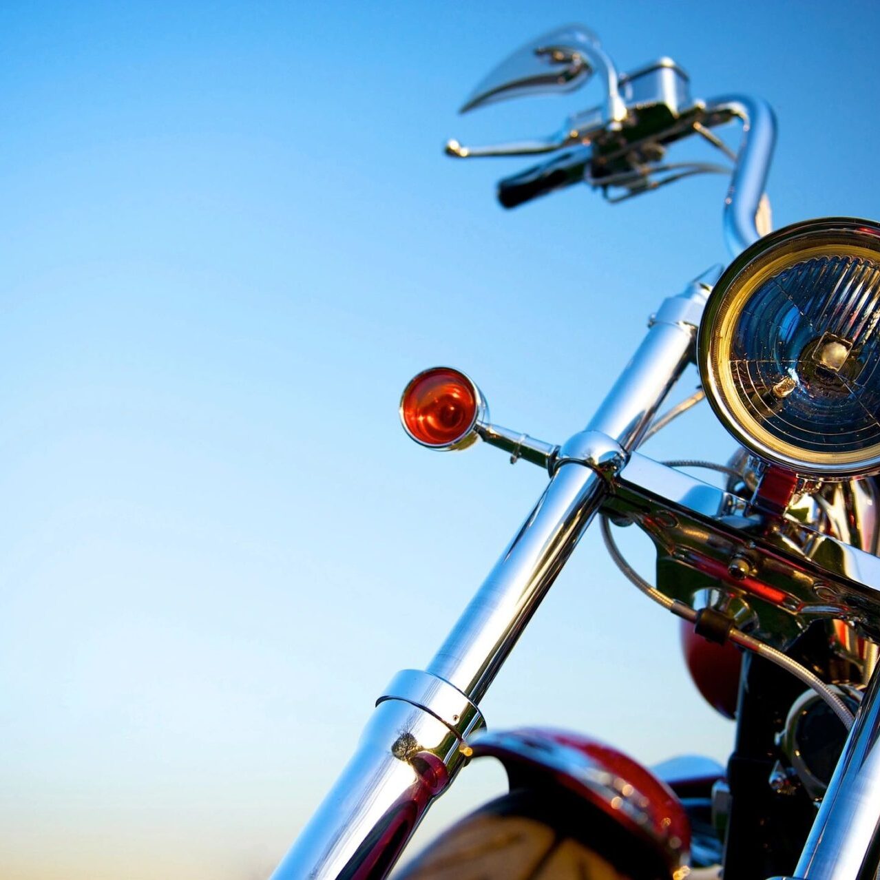 Close-up of front of motorcycle with blue sky background